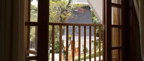 Vista desde una habitación con baranda de madera, pared blanca y ventana.