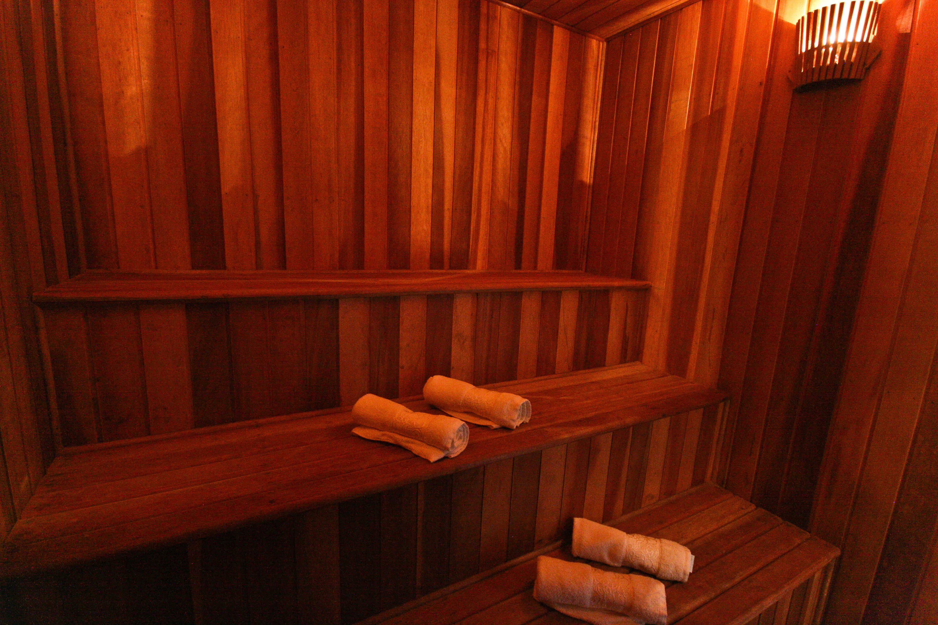 Een sauna met houten banken en handdoeken erop.