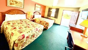 A hotel room with two beds, a desk, a chair, a television, and a door leading outside. - Weathervane Motor Court (Ronks)