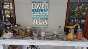 A kitchen counter with various items including jars, bottles, and a decorative rooster. - Sandpiper Guest House (St. Lucia)