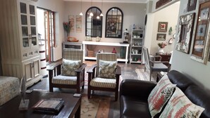 A cozy living room with a sofa, two armchairs, a coffee table, and a dining area with a table and chairs. - Sandpiper Guest House (St. Lucia)