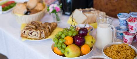 Un buffet de petit-déjeuner proposant une variété d’aliments, notamment des fruits, des viennoiseries et des céréales.