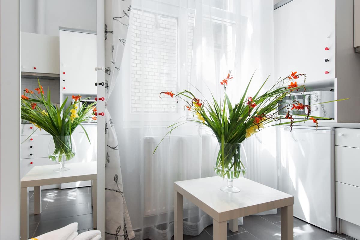 A modern bathroom with a white sink, mirror, and a shower area.