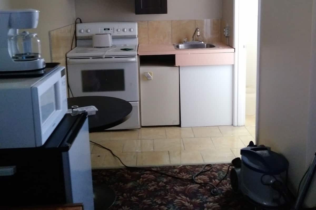 Une cuisine de taille réduite équipée d’une cuisinière, d’un four à micro-ondes et d’un évier.