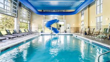 Una piscina techada, sillones reclinables de piscina