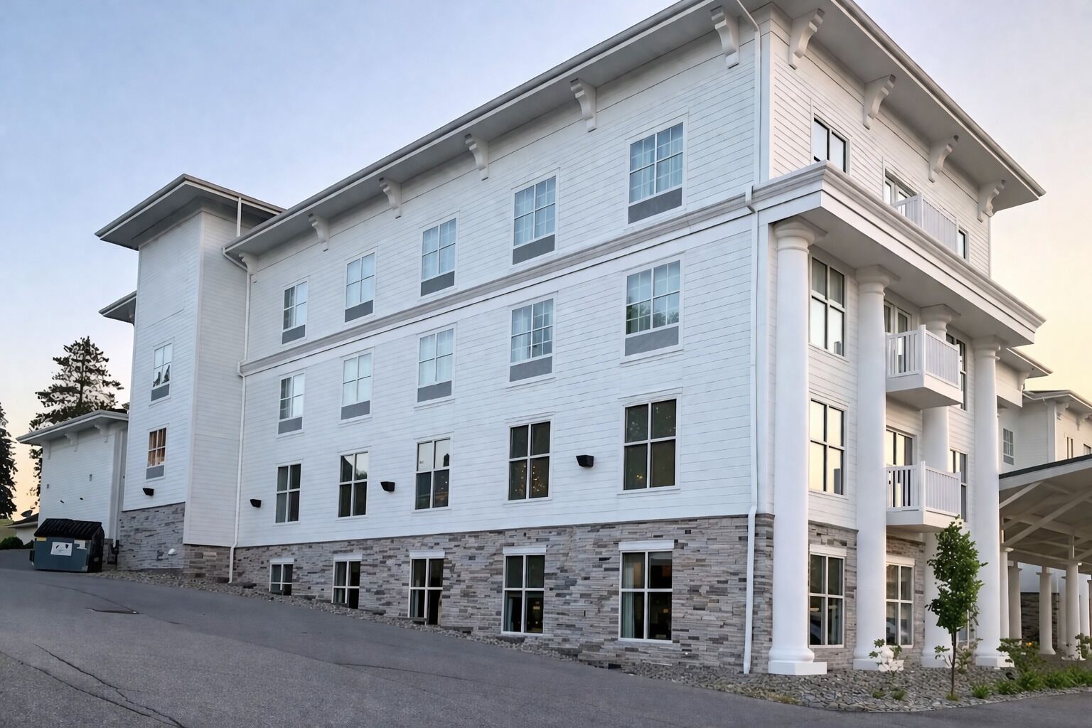 A multi-story hotel with a stone facade, large windows, and a covered entrance.
