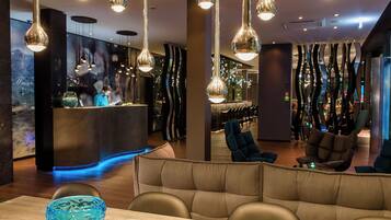 Un intérieur moderne agrémenté de luminaires suspendus, d’un comptoir d’accueil et d’espaces aménagés pour s’asseoir.
