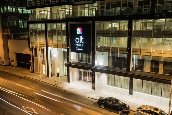 A modern hotel with a prominent sign, large windows, and a well-lit entrance. - Alt Hotel Ottawa Downtown (Ottawa)