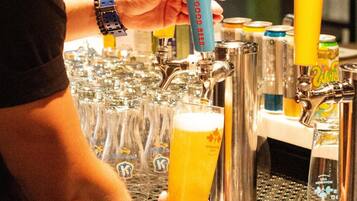 A bartender pouring beer into a glass at a bar.