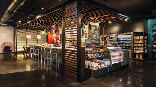 Un café moderne doté d’un comptoir, d’un espace salon et de vitrines.