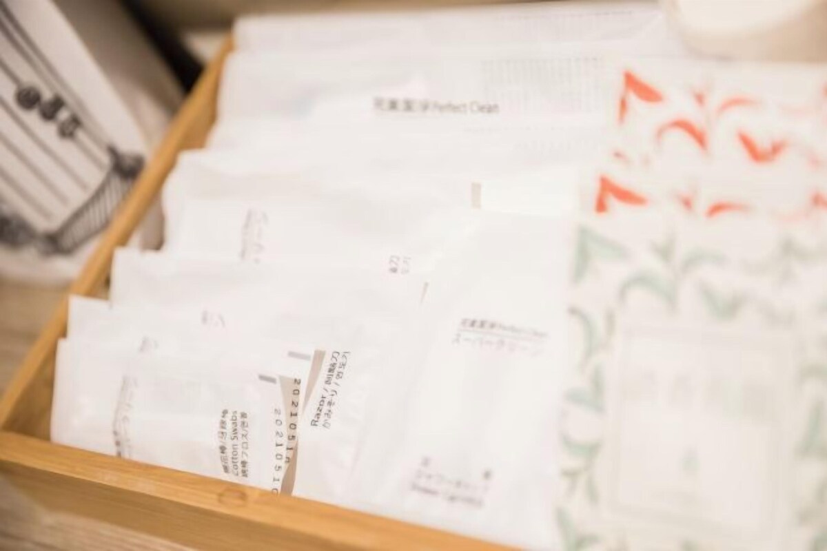 A wooden drawer containing several white packets with printed text, likely containing products or documents.