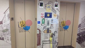 A hotel elevator with a mural of a building and the text "LIFE LIVES EXPERIENCE SOMETHING BEAUTIFUL". - Sleep Taipei Hotel Nan-Ya Branch (New Taipei City)
