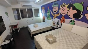 A bedroom with two beds, a desk, and a mural of cartoon characters.