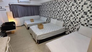 A hotel room with two beds, a desk, and a chair.
