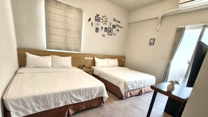 A hotel room with two beds, a small table with a vase, a wall clock, and a 'Dream House' sign. - Success 66 B&B (Taitung)
