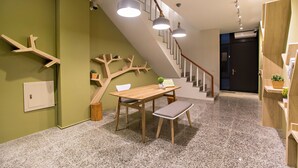 A modern interior with a staircase, a wooden table with a bench, and pendant lighting. - Success 66 B&B (Taitung)