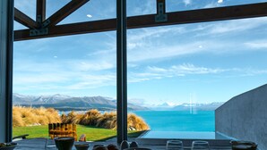 Una mesa de comedor con alimentos para el desayuno y vistas a montañas y un lago.