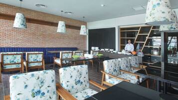 Un restaurante moderno con paredes de ladrillo, muebles de madera y sillas con estampado floral.