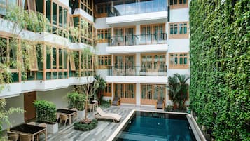 Una piscina al aire libre, sillones reclinables de piscina