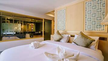 Una habitación de hotel con una cama grande, un espejo y un biombo decorativo.
