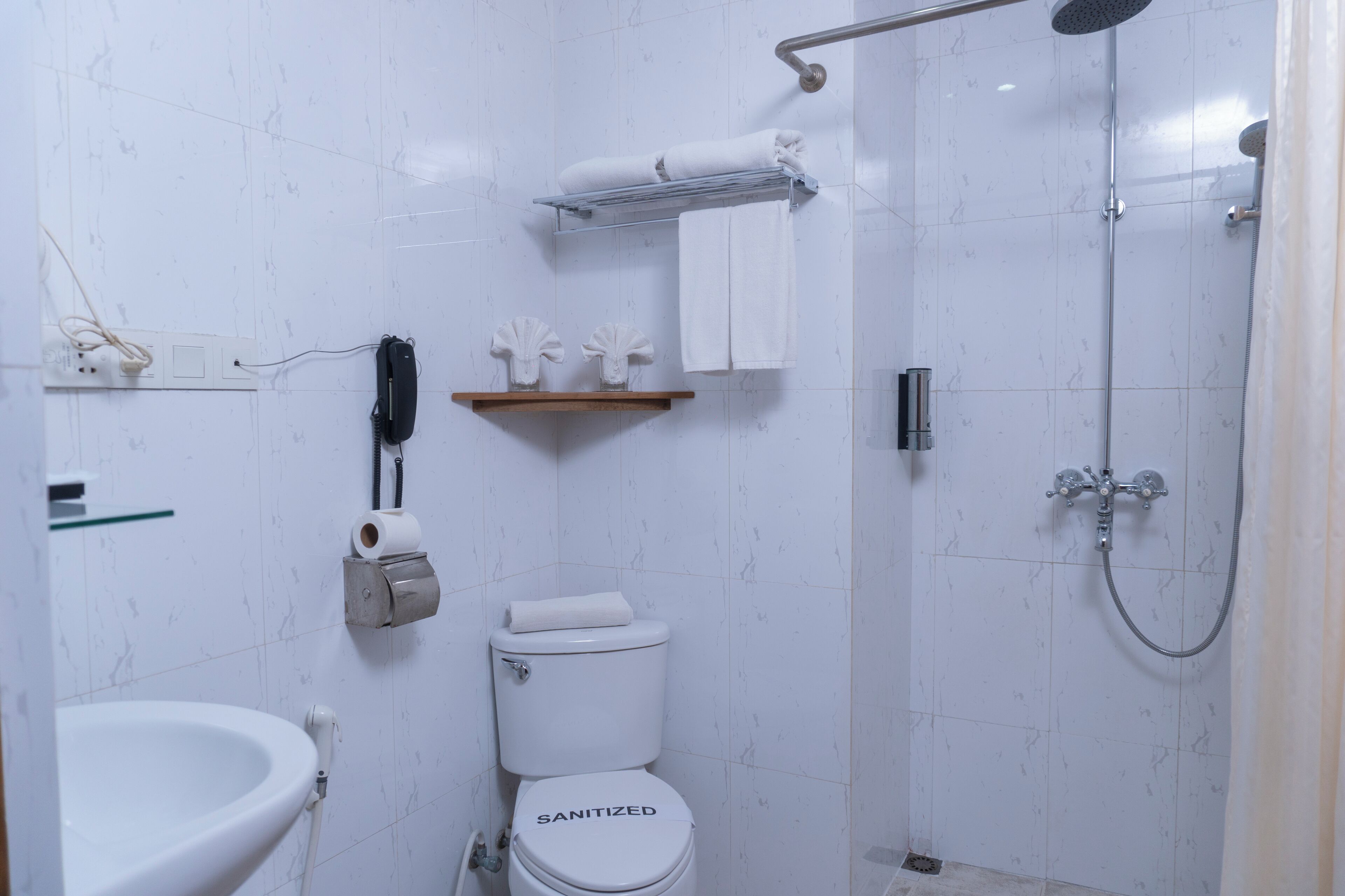 Un baño con inodoro, lavamanos, ducha y toallero.