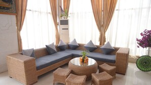 Ein modernes Wohnzimmer mit einem Ecksofa, einem runden Couchtisch und passenden Sesseln.