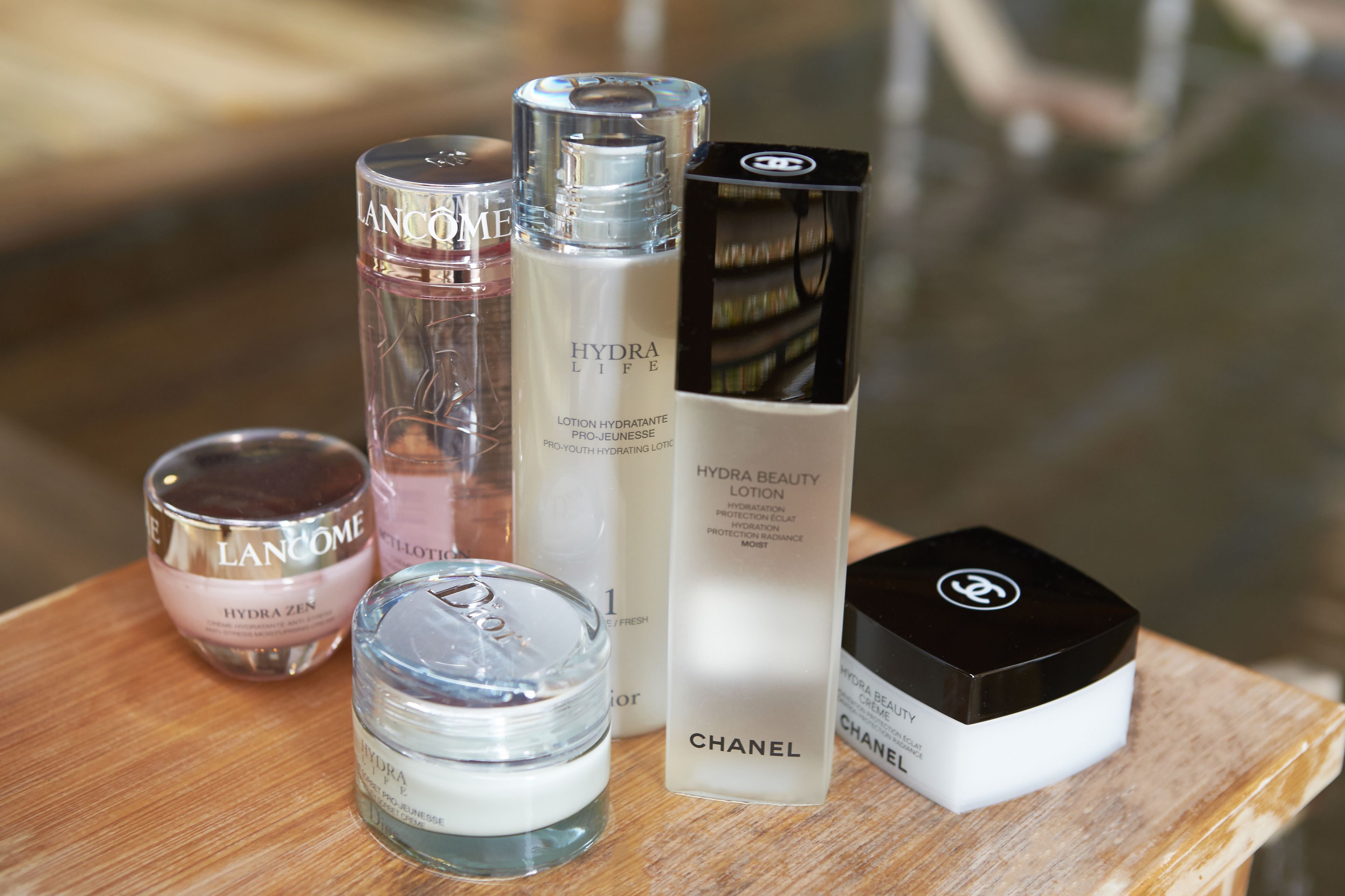 A collection of skincare products on a wooden surface.