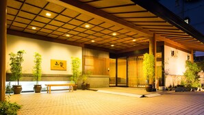 A traditional Japanese building with a tiled entrance, potted plants, and a wooden bench. - Kinugawa Onsen Sanraku (Nikko)