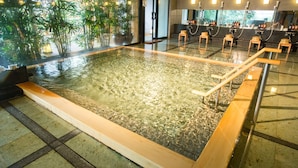 A large indoor swimming pool with clear water, surrounded by tiled flooring and wooden benches. - Kinugawa Onsen Sanraku (Nikko)