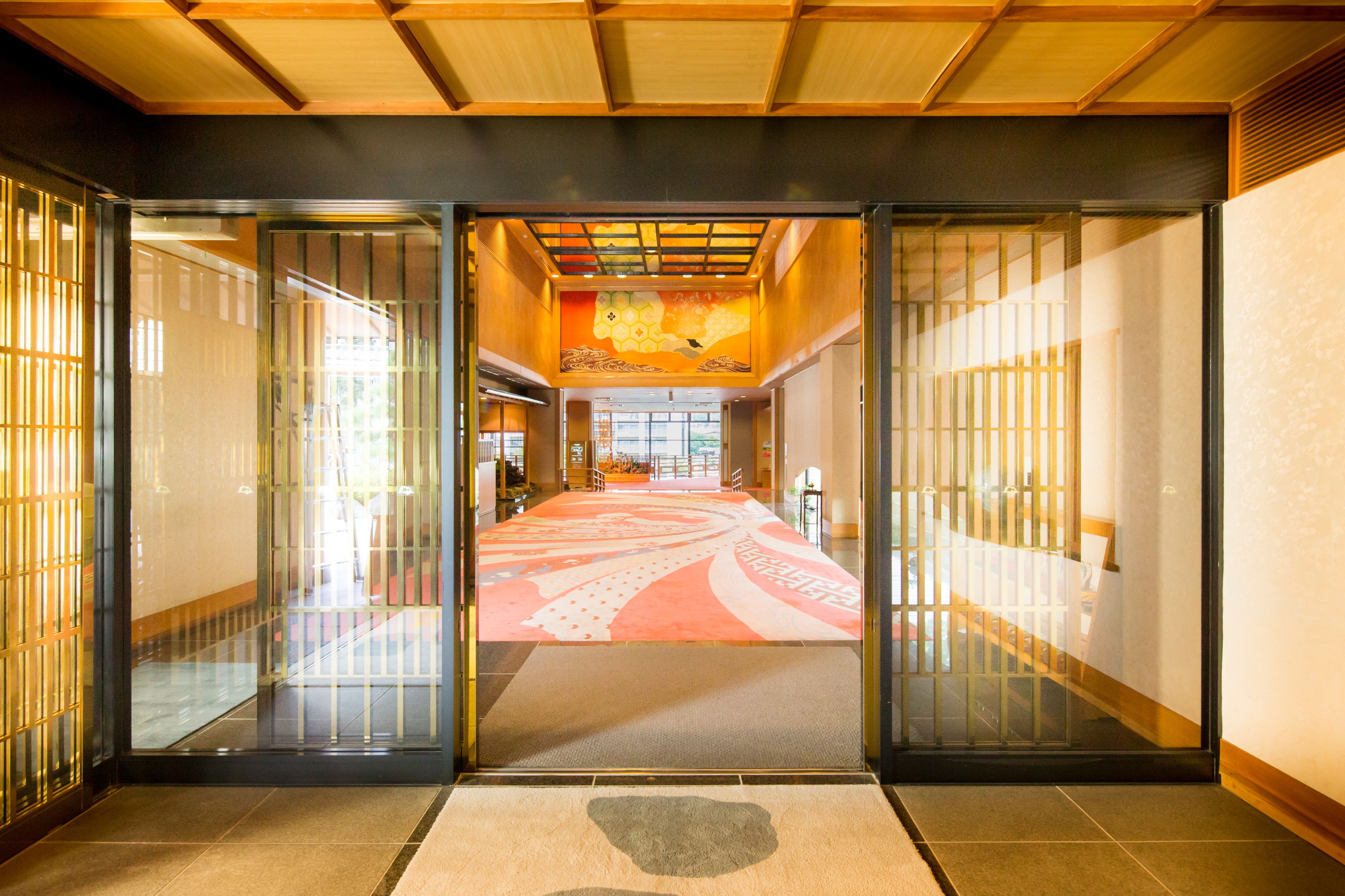 A traditional Japanese interior with sliding doors, a tatami mat floor, and a decorative ceiling.