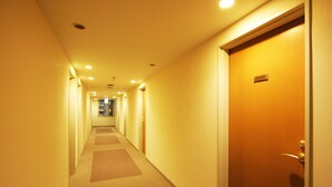 A hotel hallway with carpeted floors and a wooden door with a number plate. - Kochi Green Hotel Harimayabashi (Kochi)