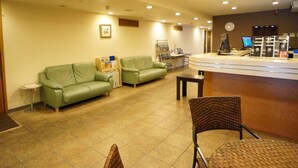 A reception area with a counter, two green sofas, a wicker chair, a small table, and a magazine rack. - Kochi Green Hotel Harimayabashi (Kochi)