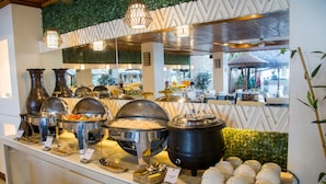 A buffet setup with various food containers and serving utensils. - Sur Beach Resort (Boracay Island)