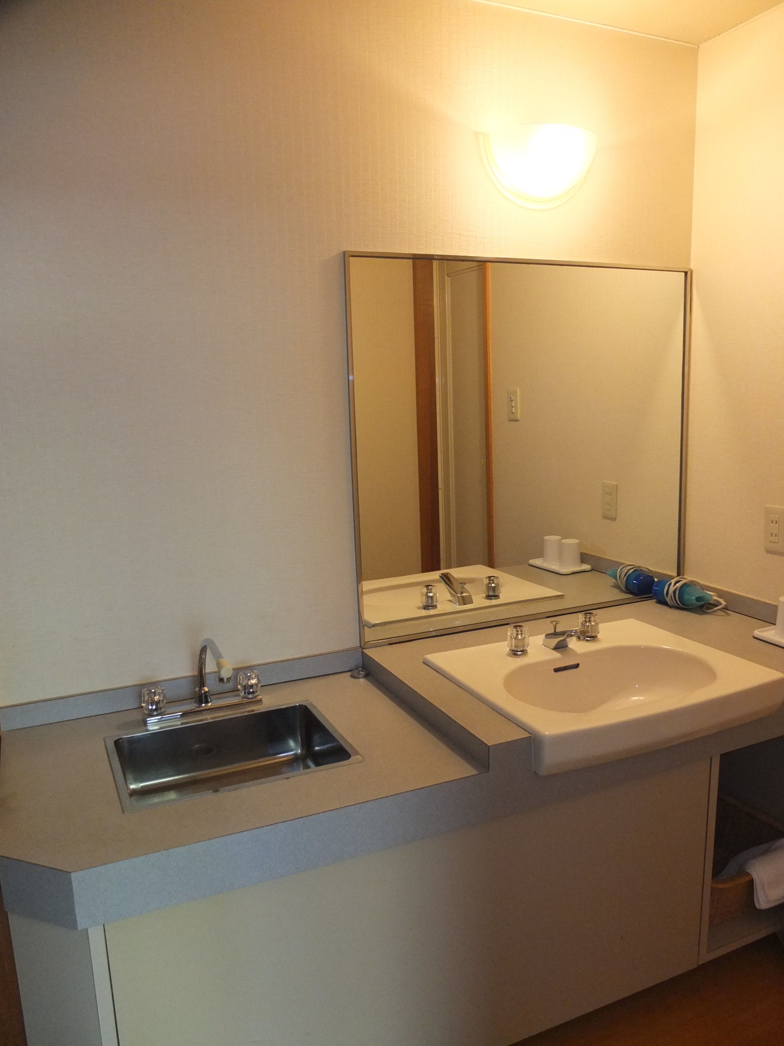 A bathroom with a double sink, a mirror, and a towel rack.