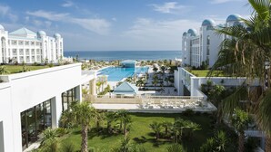 A resort with a large pool, palm trees, and a view of the ocean. - Hotel Concorde Green Park Palace (Port El Kantaoui)