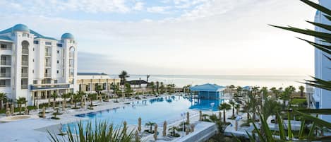 Alberca techada, alberca al aire libre y sombrillas en la alberca