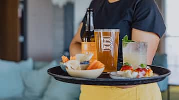 Un plateau avec une bouteille, un verre et un bol de nourriture.