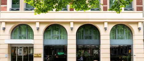 Un edificio con tres ventanas arqueadas y una puerta de cristal.