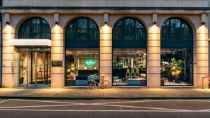 A building with arched windows and a bicycle parked outside. - Hotel The Dutch (Maastricht)