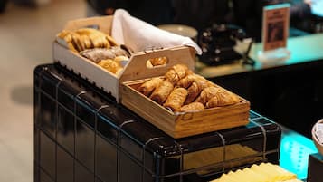 Un bufé de desayuno con diversos pasteles y pan.