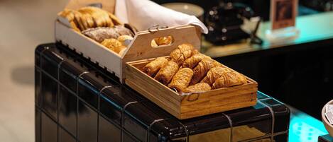 Ein Frühstücksbuffet mit verschiedenen Backwaren und Brot.