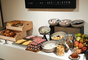 Indulge in a delicious buffet spread featuring a variety of fresh fruits, pastries, and spreads.