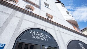 A building with a sign reading "MAISON Schiller" and a blue sign indicating "20". - Maison Schiller (Munich)