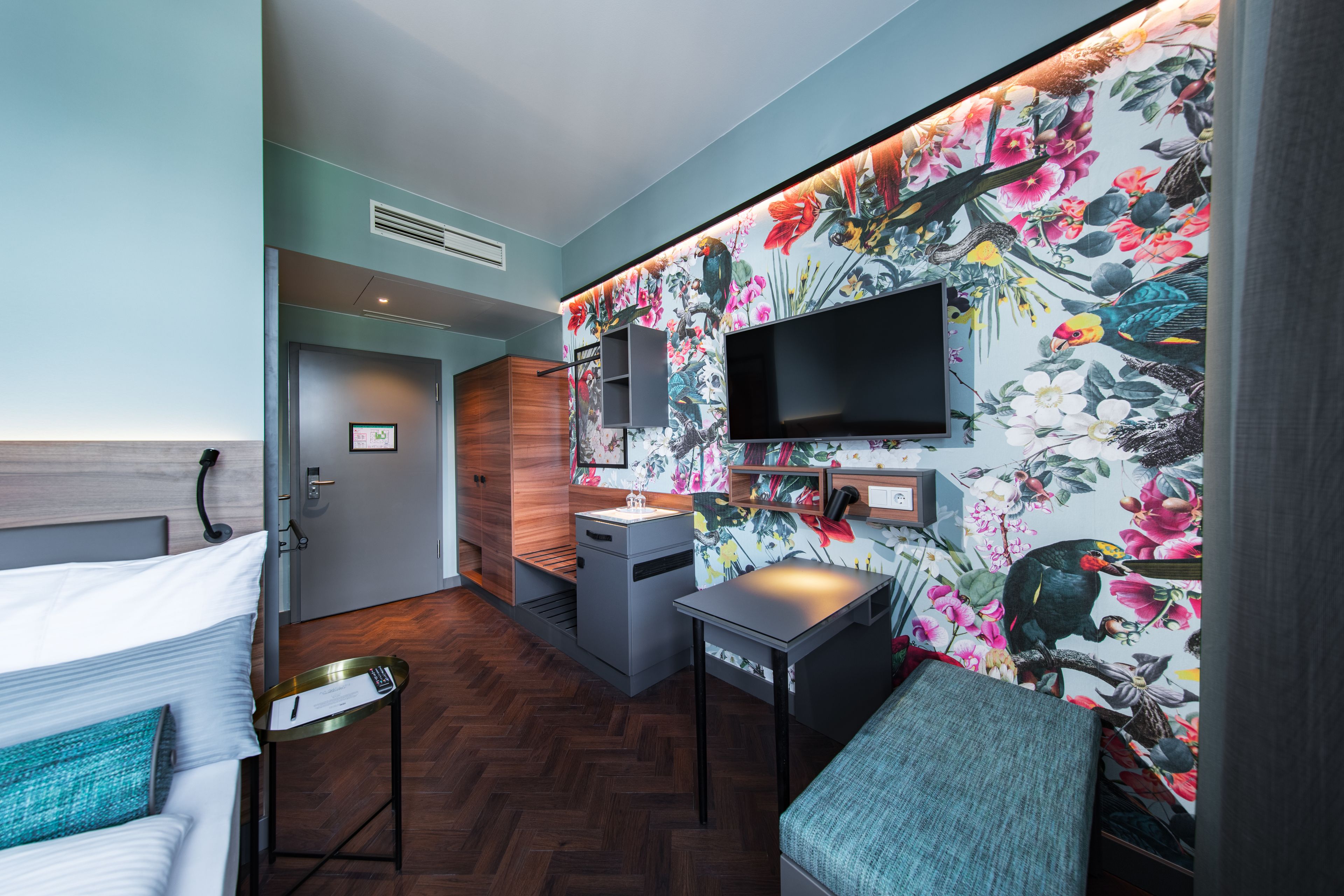 Een hotelkamer met een bed, een bureau, een stoel, een televisie en een badkamer.