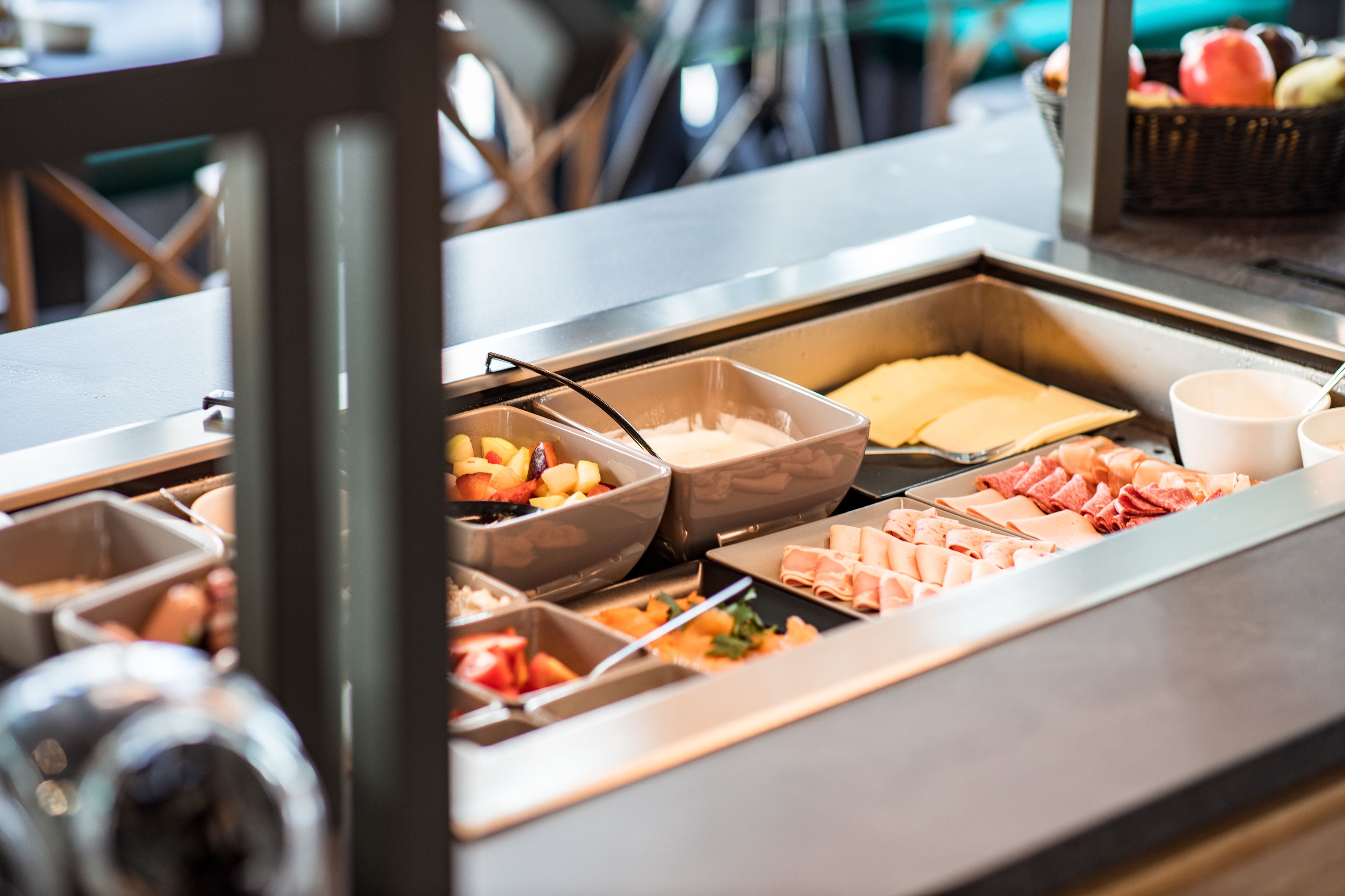 Un buffet proposant une variété de plats, notamment des fruits, des fromages et des viandes.