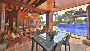 A wooden interior with a dining area, a pool, and a traditional gazebo.