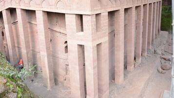 Une grande structure circulaire en briques, dotée d’un toit plat et de nombreuses colonnes.
