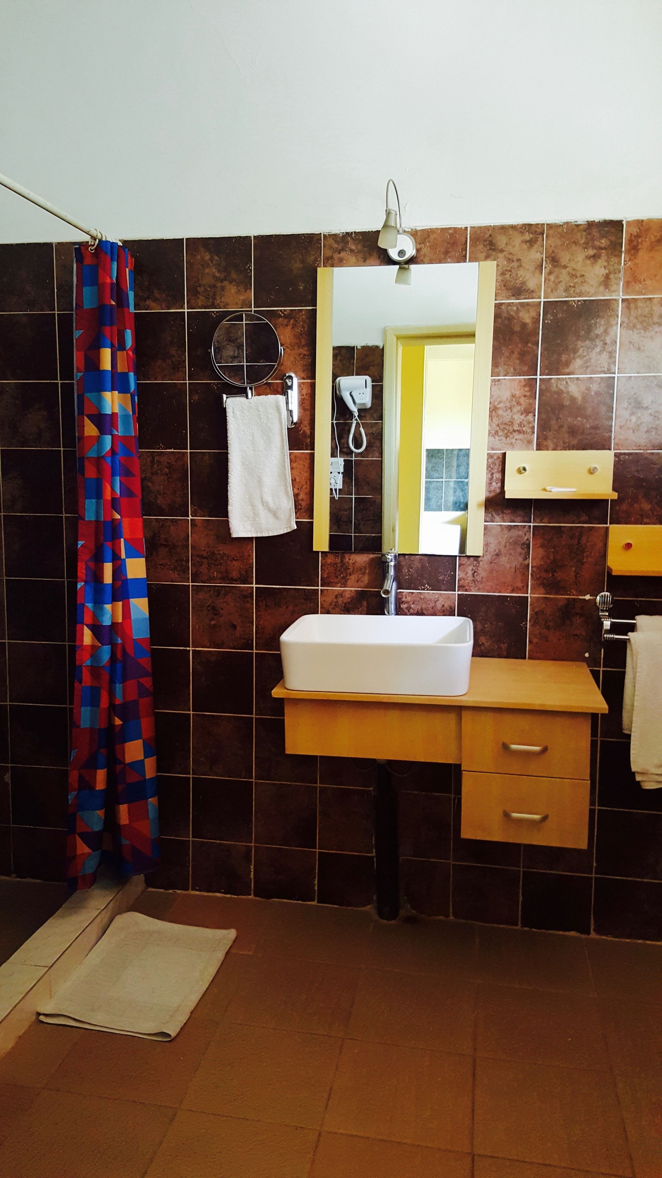 A bathroom with a white sink, a mirror, a towel rack, and a shower curtain.