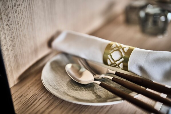 Un juego de mesa ordenado con un plato, una cuchara y palillos sobre una mesa de madera.