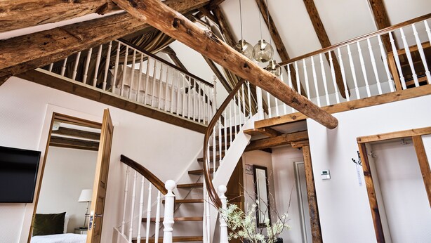 A staircase with wooden beams and white railings, leading to an upper floor. - Bekkjarvik Gjestgiveri | Beckerwyc House (Austevoll)